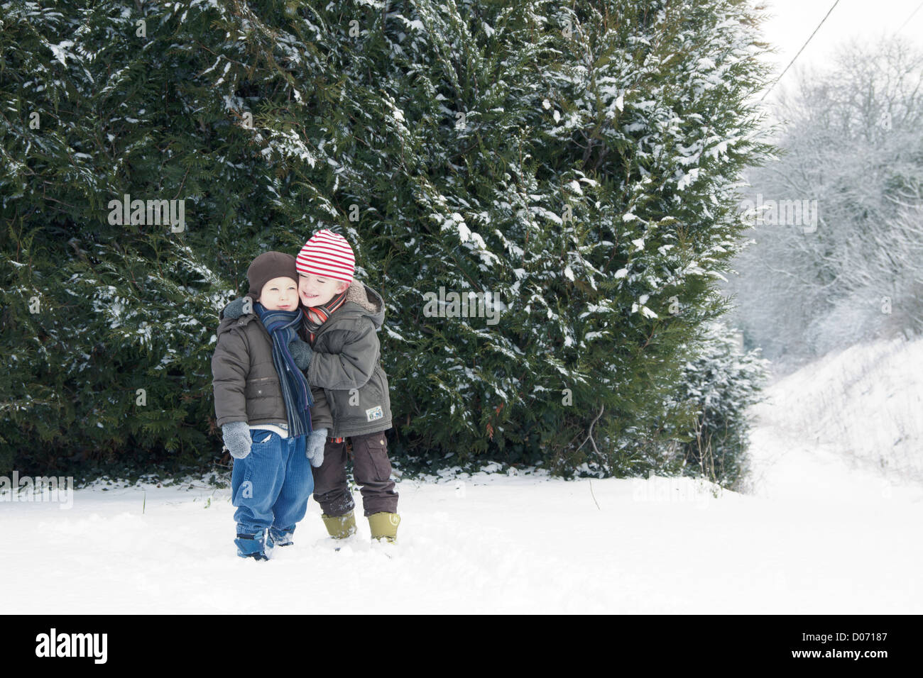 Jungs spielen zusammen im Schnee. Stockfoto