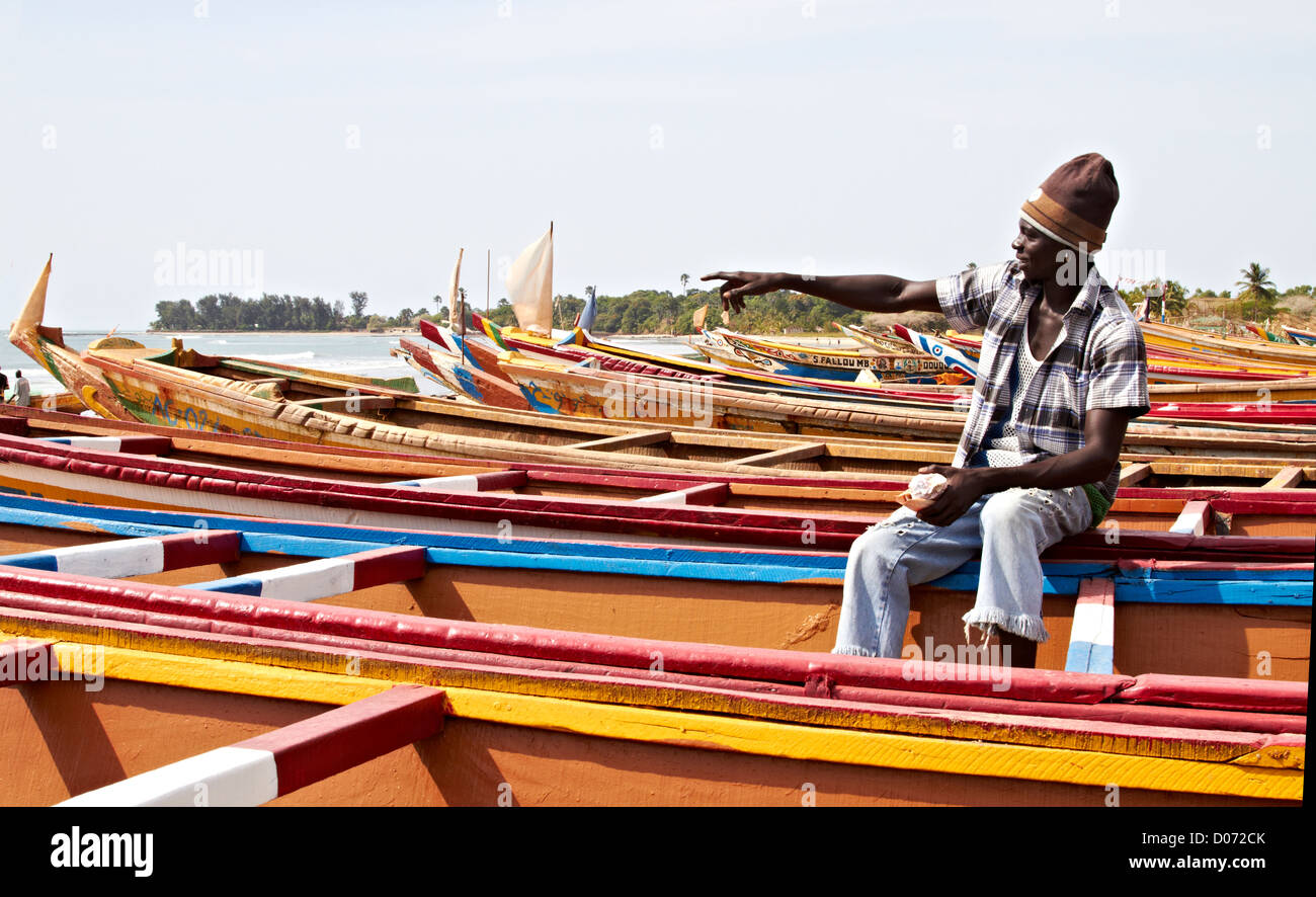 Gambische Fischer mit Booten am Ufer Stockfoto