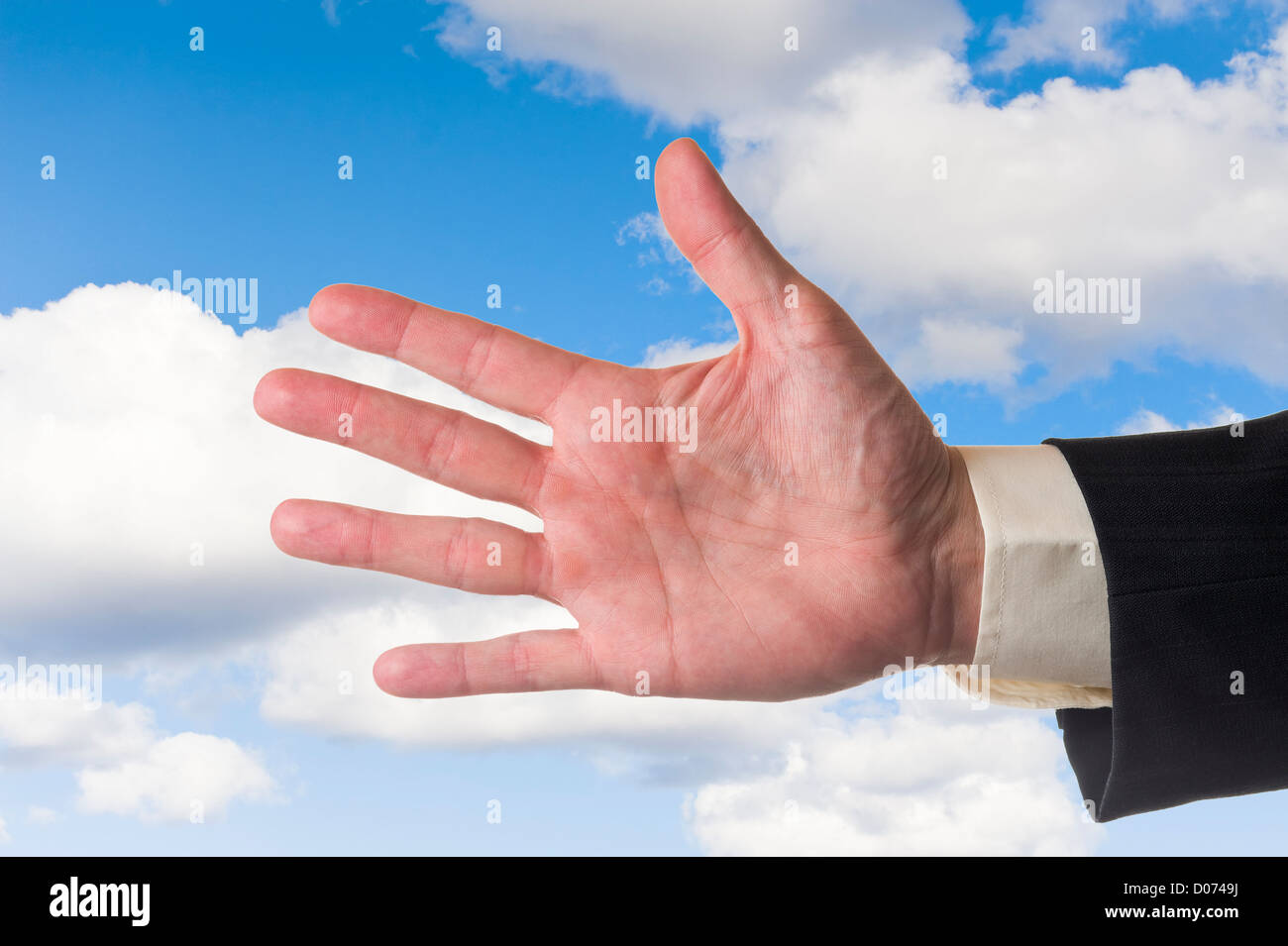 Mans Hand, zeigt fünf Finger, bewölkten blauen Himmelshintergrund. Stockfoto