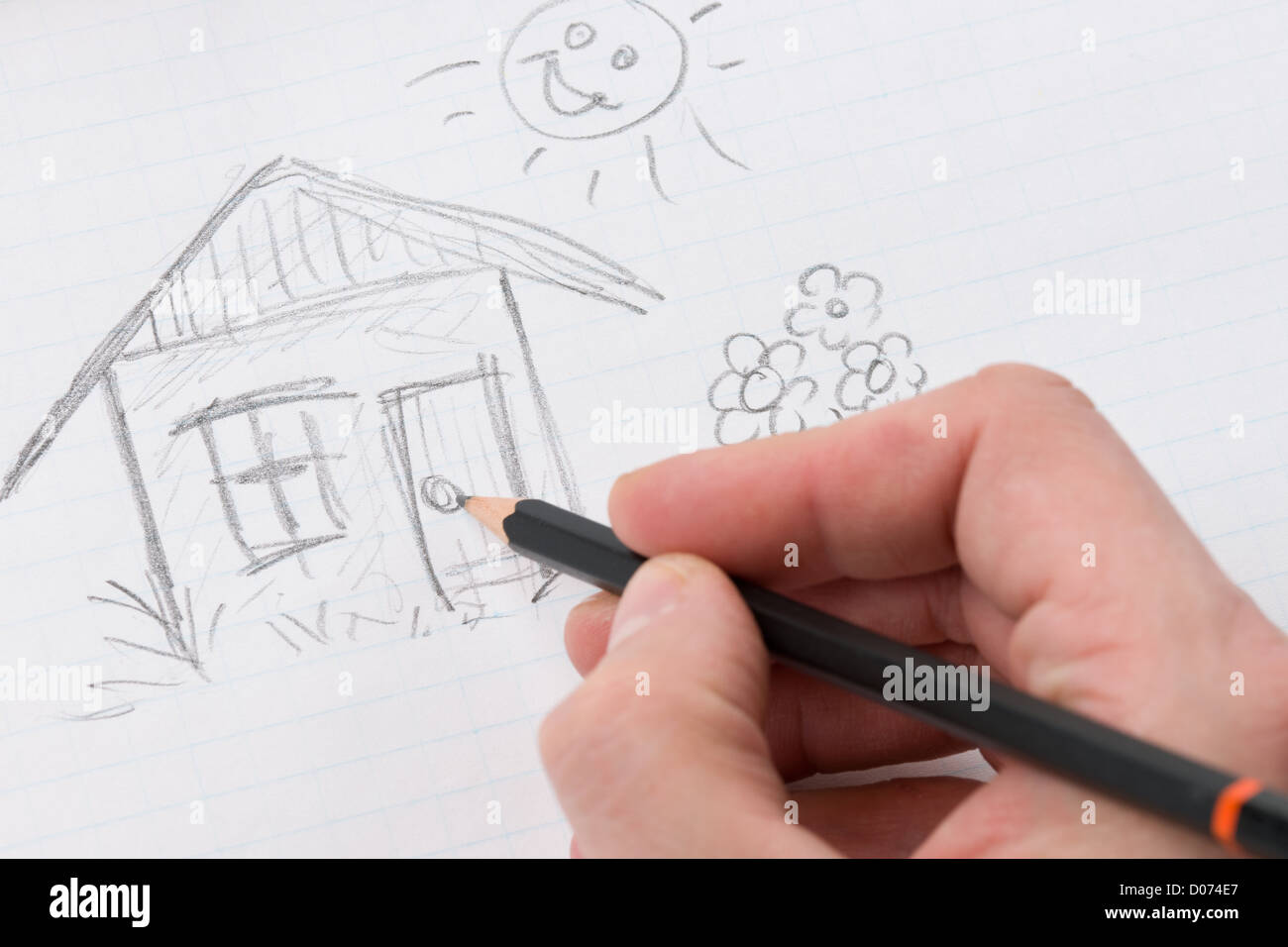 Ein Mann, zeichnen ein Bild, kleines Haus und Sonne. Stockfoto