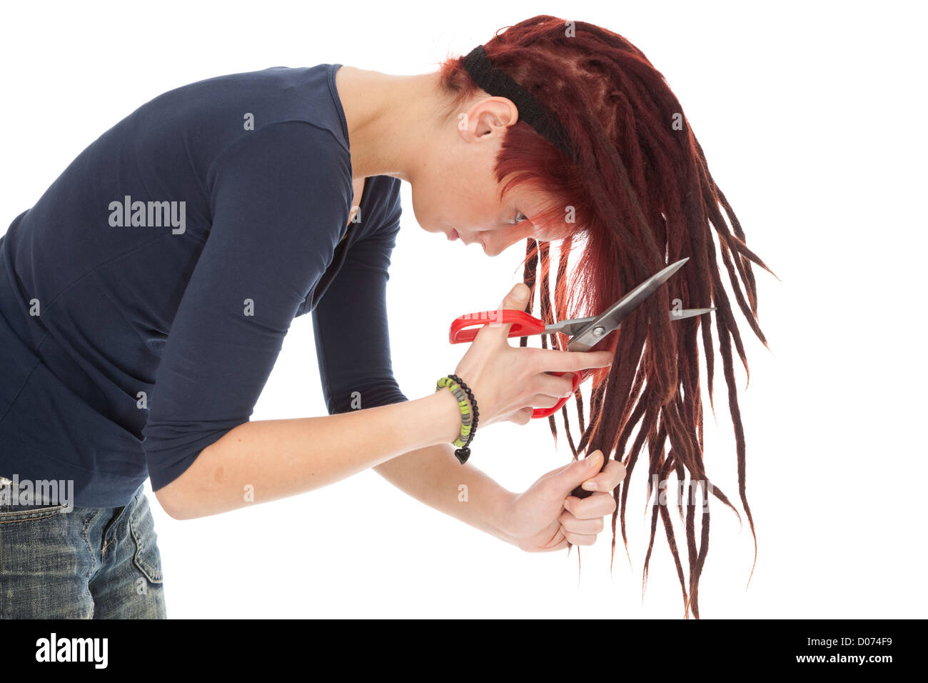 rothaarige Mädchen schneiden Dreadlocks auf weißem Hintergrund Stockfoto