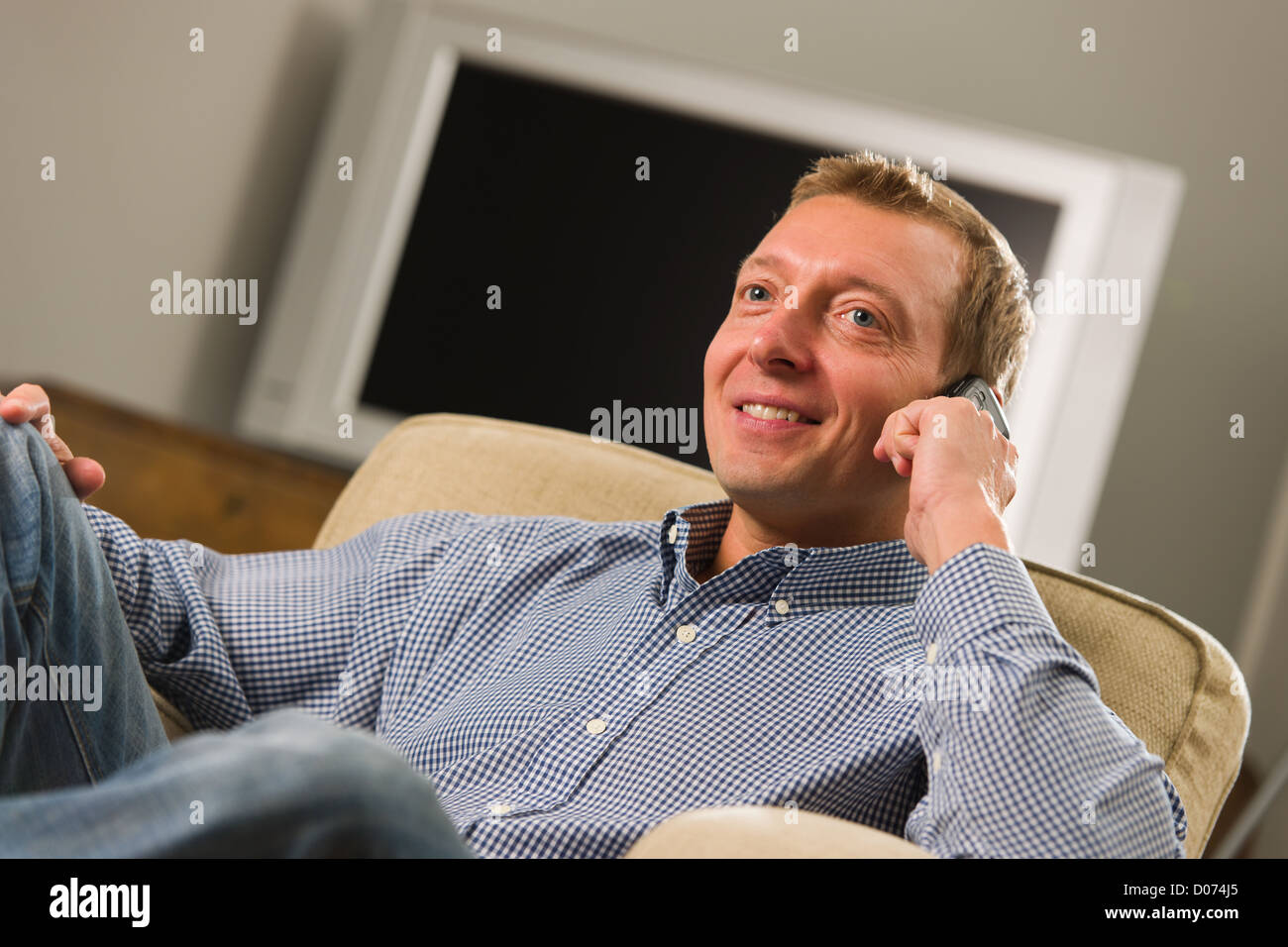 Man sitzt auf dem Sessel und sein Handy zu verwenden. Stockfoto