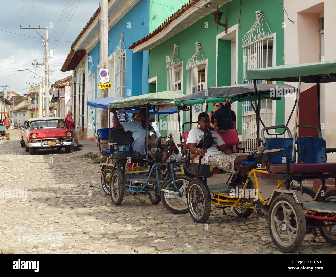 Kubanische Dreirad-Taxi-Betreiber warten, für das Geschäft in eine typische Straßenszene in Trinidad Kuba Stockfoto