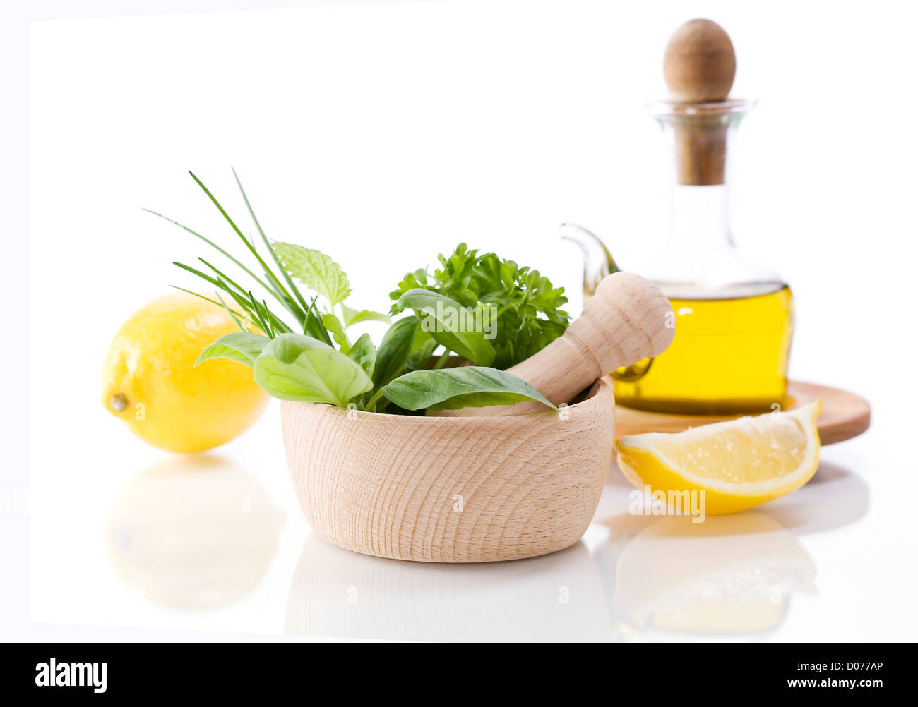 Olivenöl, heilende Kräuter und Zitrone über weiß Stockfoto