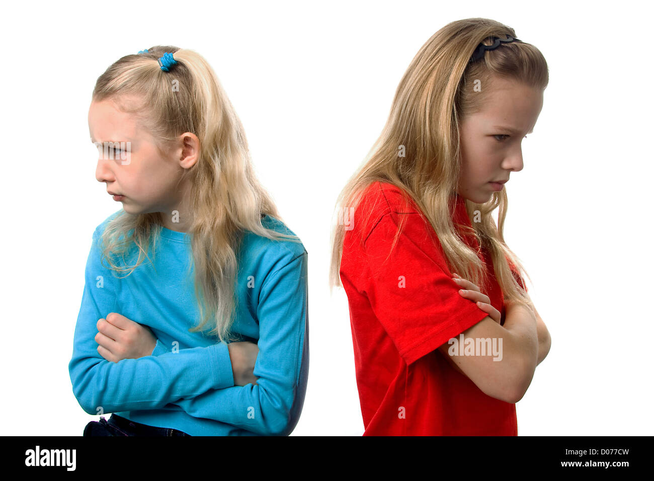 Zwei junge blonde Mädchen sind wütend auf einander auf weißem Hintergrund Stockfoto