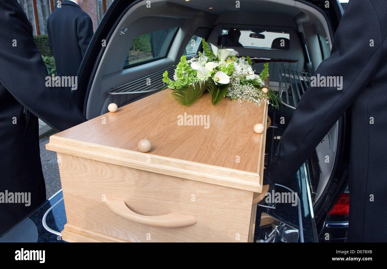 Träger tragen einen Sarg in einer Trauer-Auto Stockfoto