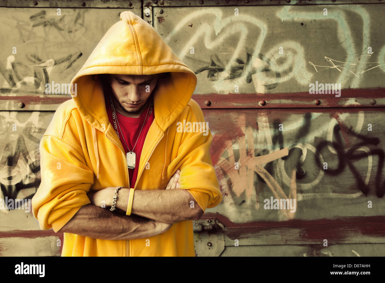 Junger Mann Porträt in Sweatshirt mit Kapuze / Jumper auf Grunge-Graffiti-Wand Stockfoto