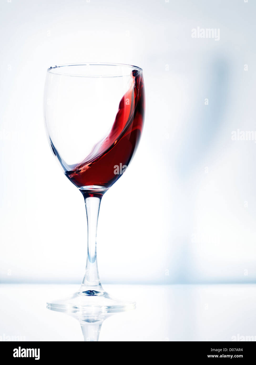 Rotwein in ein Glas künstlerische dynamisches Foto auf hellen Hintergrund isoliert Stockfoto