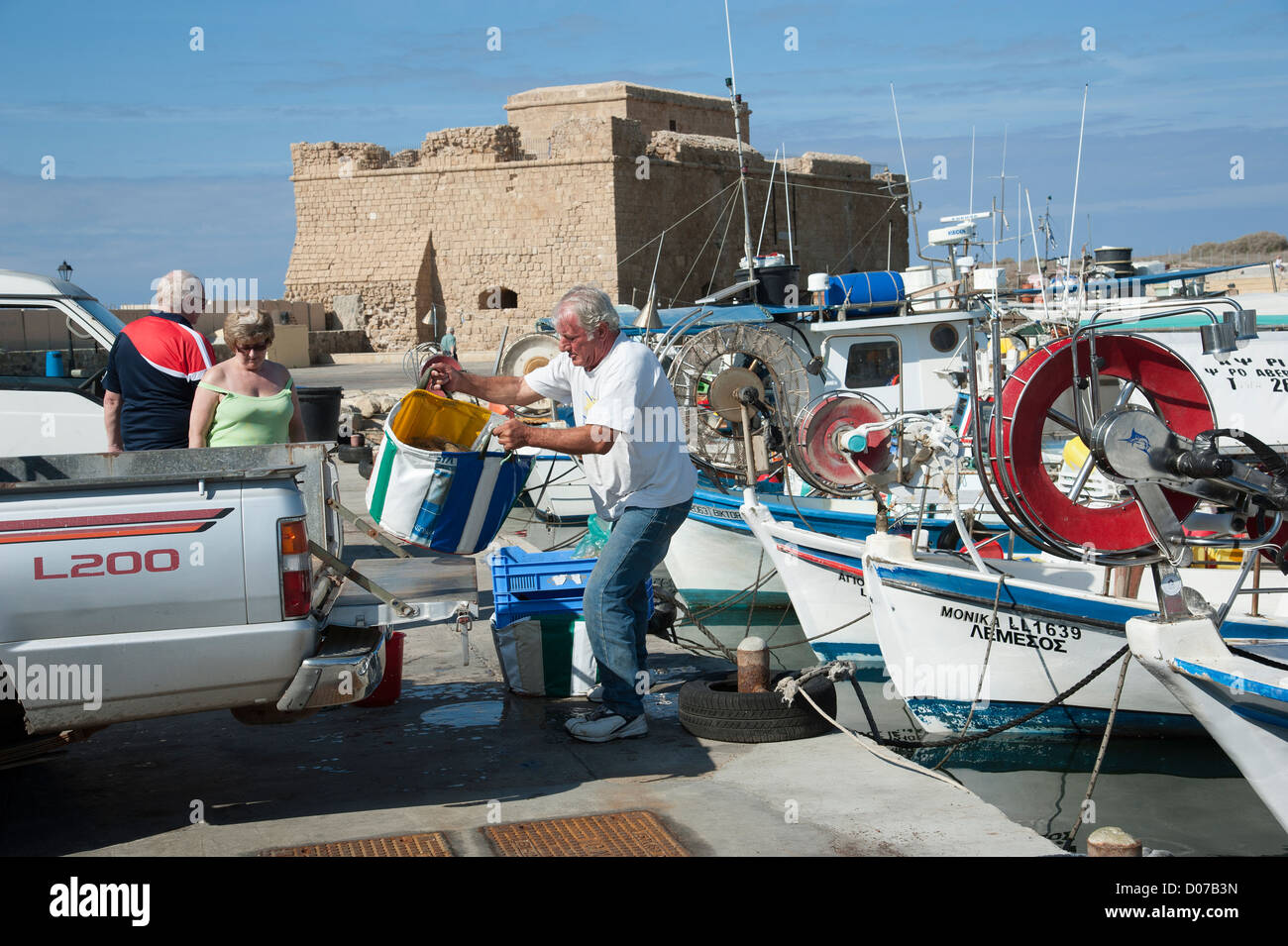 Mittelalterliche Festung von Pafos mit Blick auf die Fischerboote auf Paphos Hafen südlichen Zypern Fischer seinen Fang von Touristen beobachtet werden geladen Stockfoto