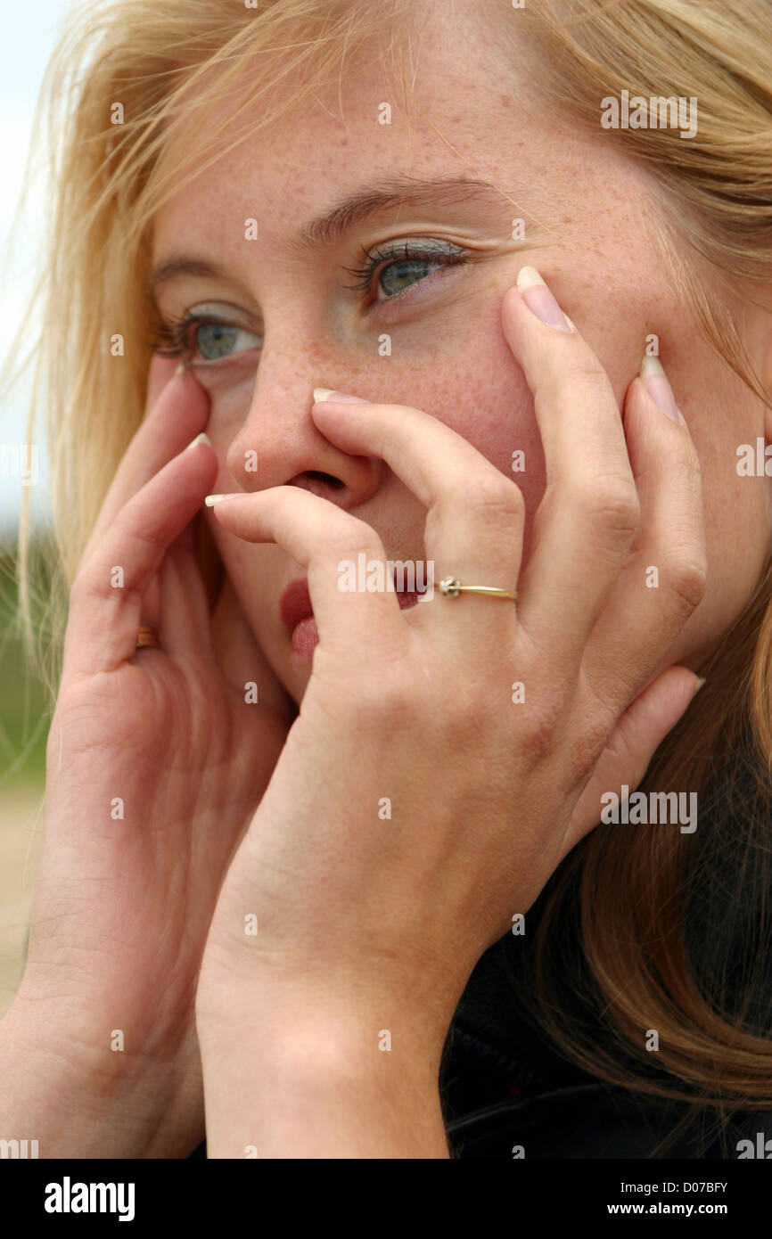 Nachdenkliche junge Frau außerhalb Hand im Gesicht, unglückliche Dame SerieCVS600002MS hautnah Stockfoto