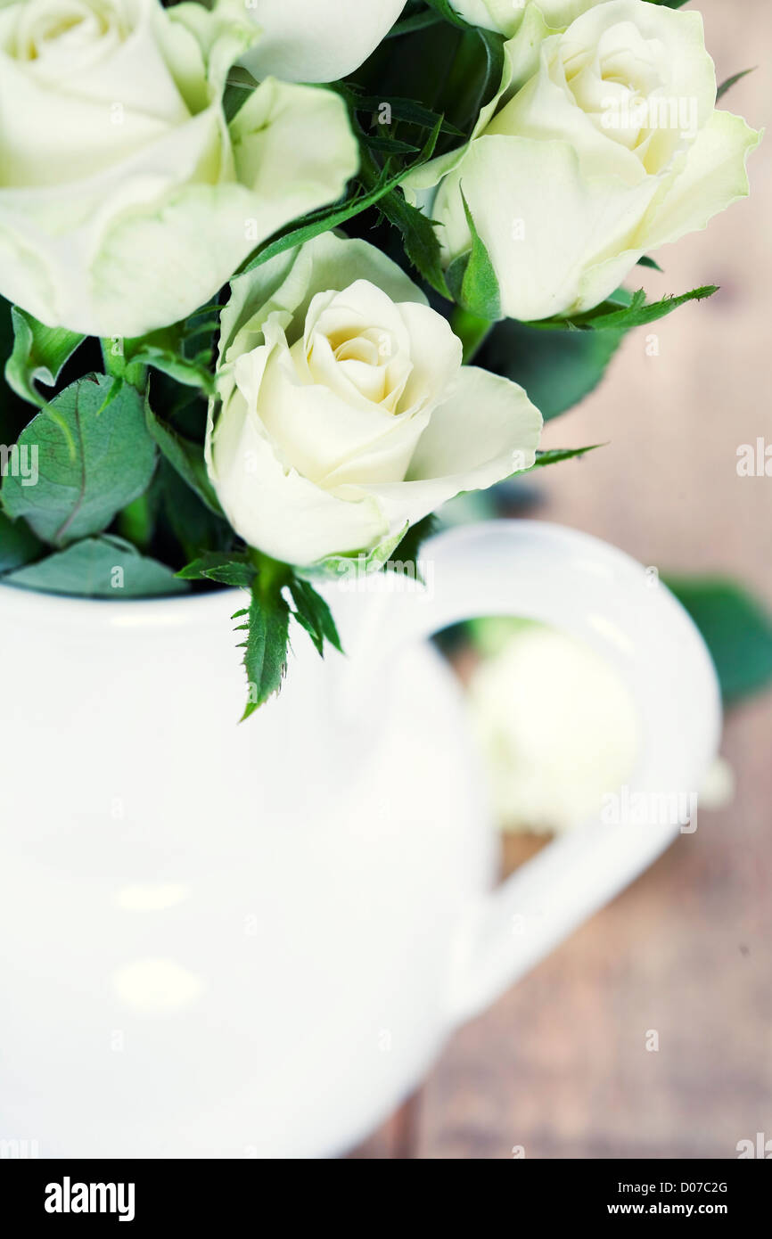 Bouquet von weißen Rosen in Vase auf Tisch Stockfoto