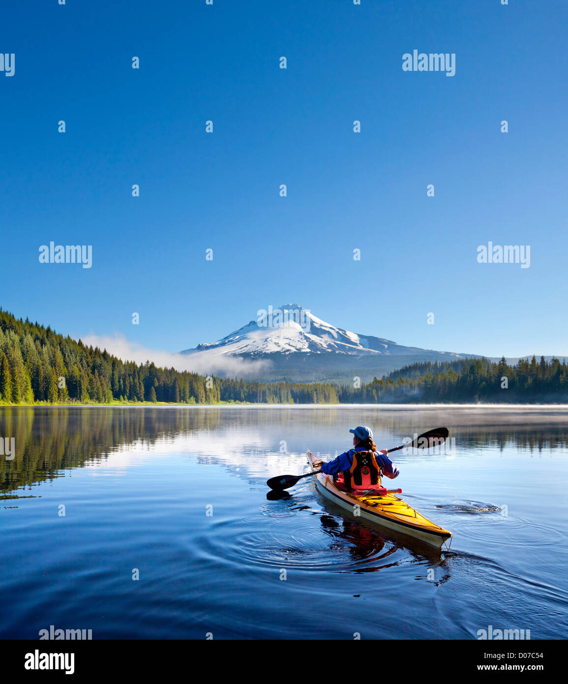 USA, Oregon. Eine Frau in einem Kajak Paddel auf Trillium Lake, Oregon, Oregon Cascades, mit Mt. Hood im Hintergrund. (MR) Stockfoto