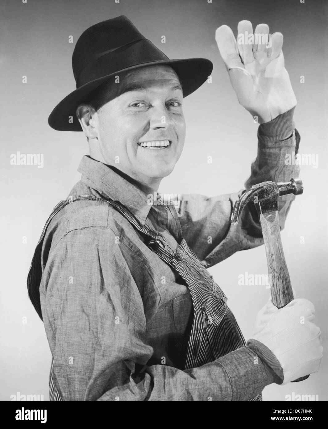 Porträt von Zimmermann winken und halten hammer Stockfoto