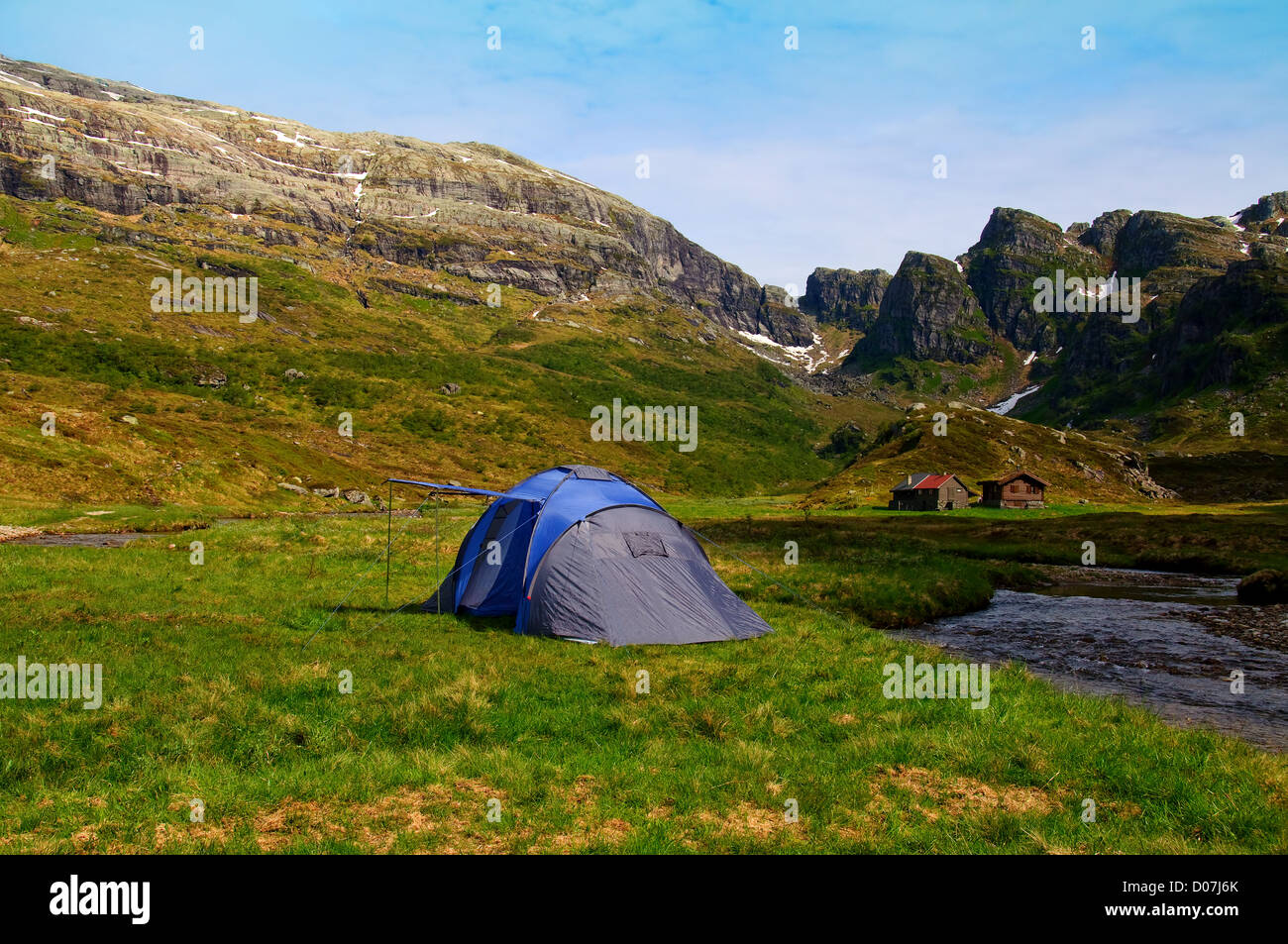 Camping Zelt in den Bergen durch einen Fluss und eine Alm Stockfoto