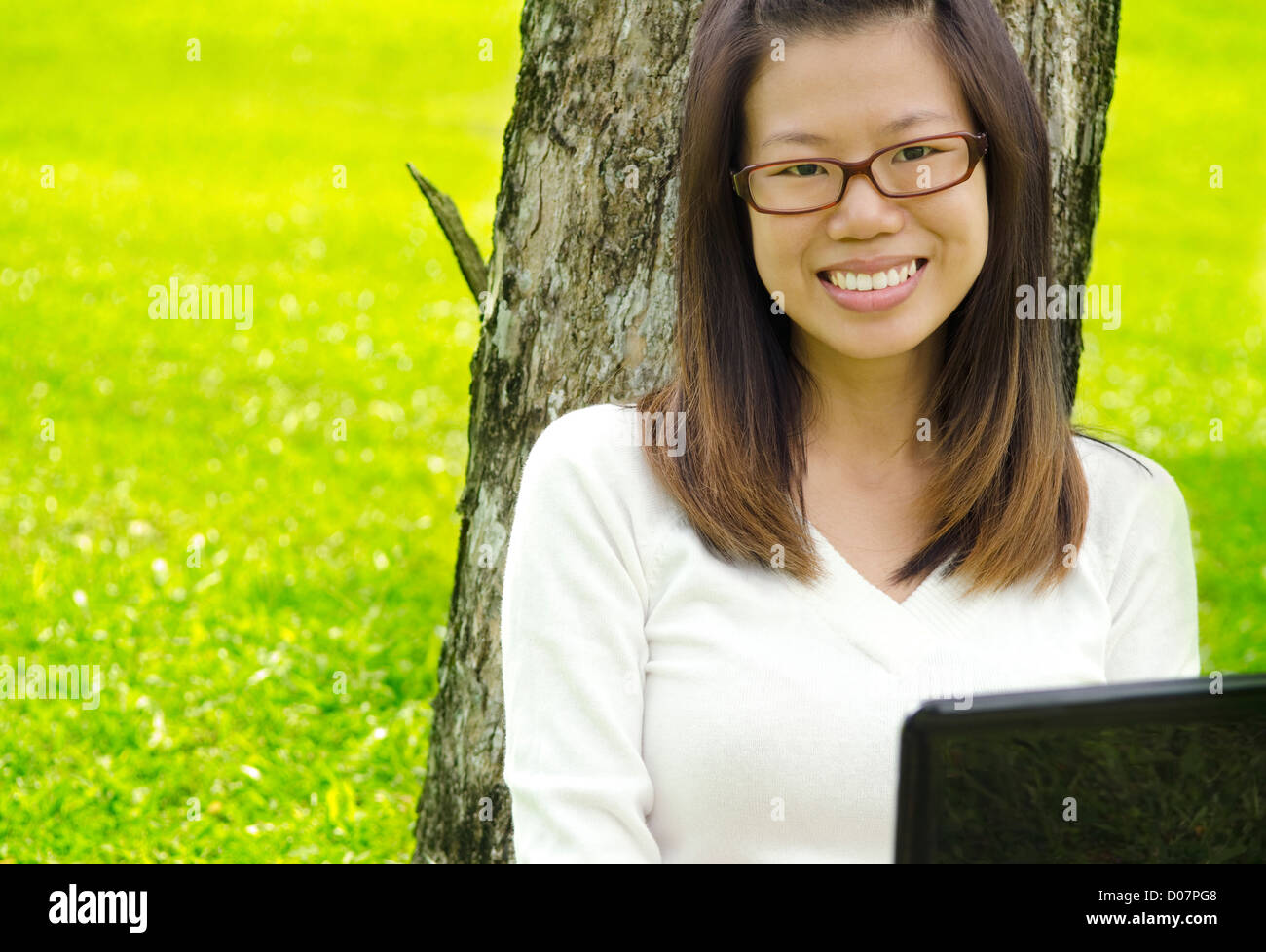 Asiatische Studentin mit Laptop außen Schulcampus Stockfoto