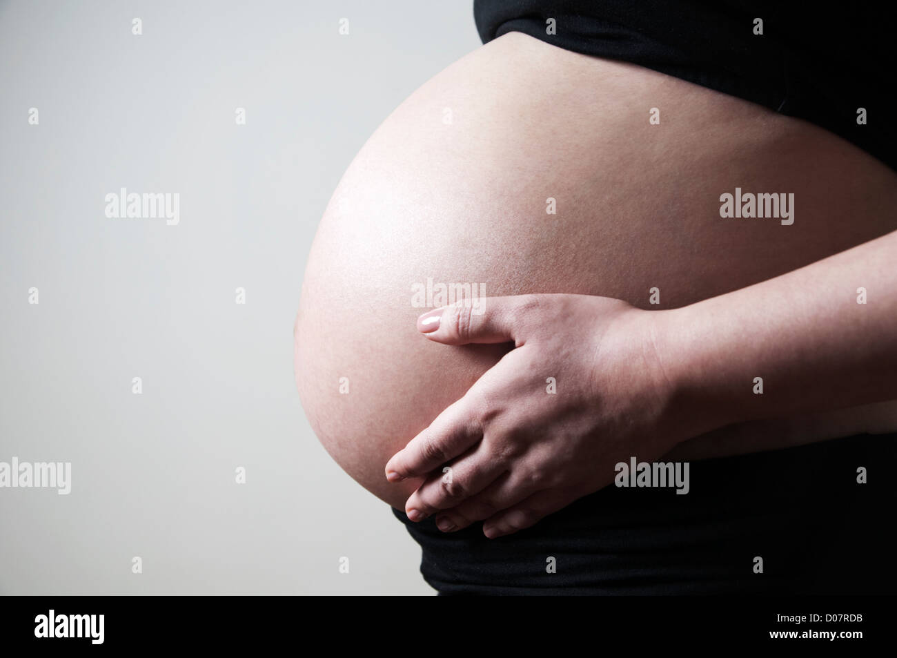 Frau mit ihren 8 Monaten Schwangerschaft Bauch Stockfoto