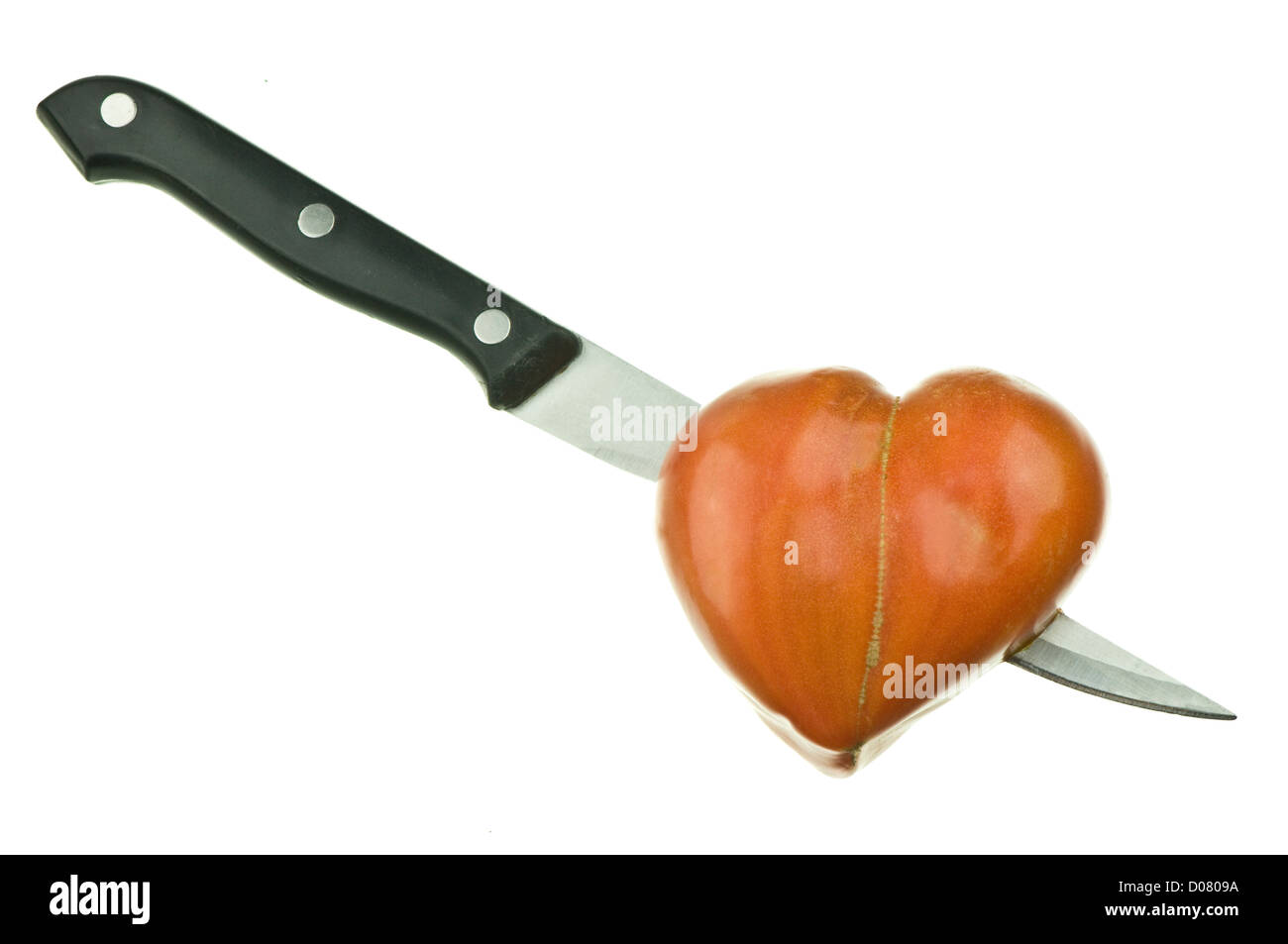 herzförmige Tomaten durchbohrt mit einem Messer auf reinen weißen Hintergrund Stockfoto