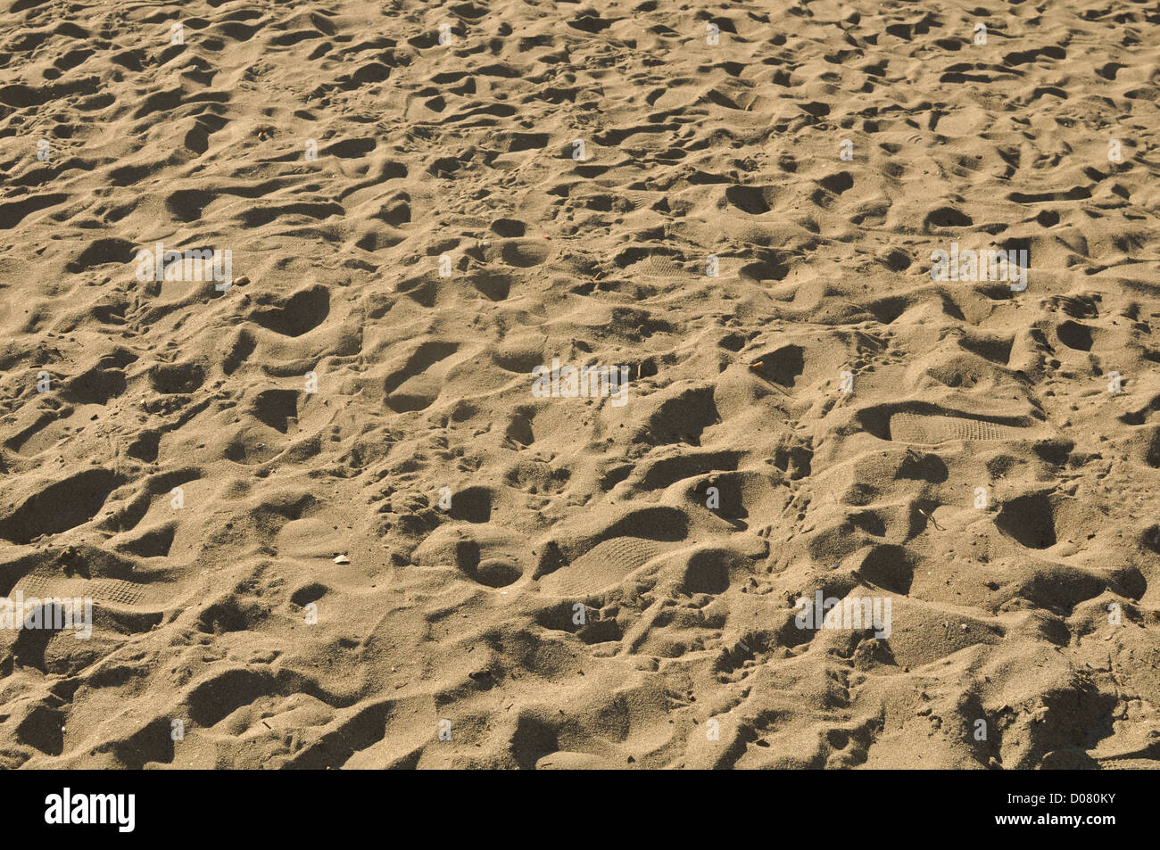 Sand-Hintergrund mit mehreren Fussspuren Stockfoto