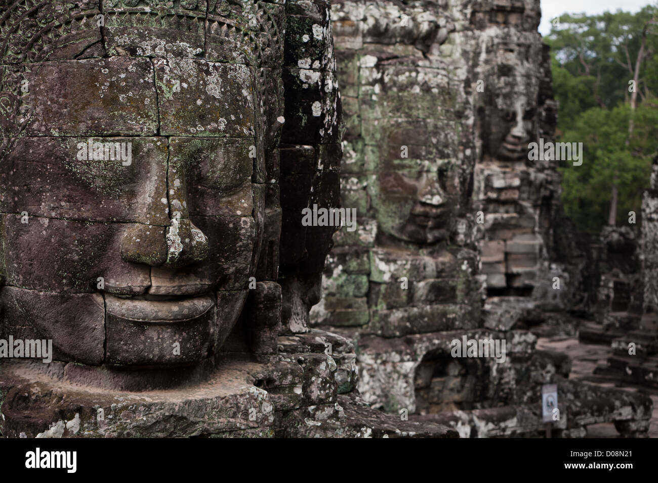 Nahaufnahme des Gesichts detail von eine Reihe von berühmten Stein gemeißelten Kopf Statuen in Angkor Wat alten prasat Bayon Tempel Ruinen Stockfoto