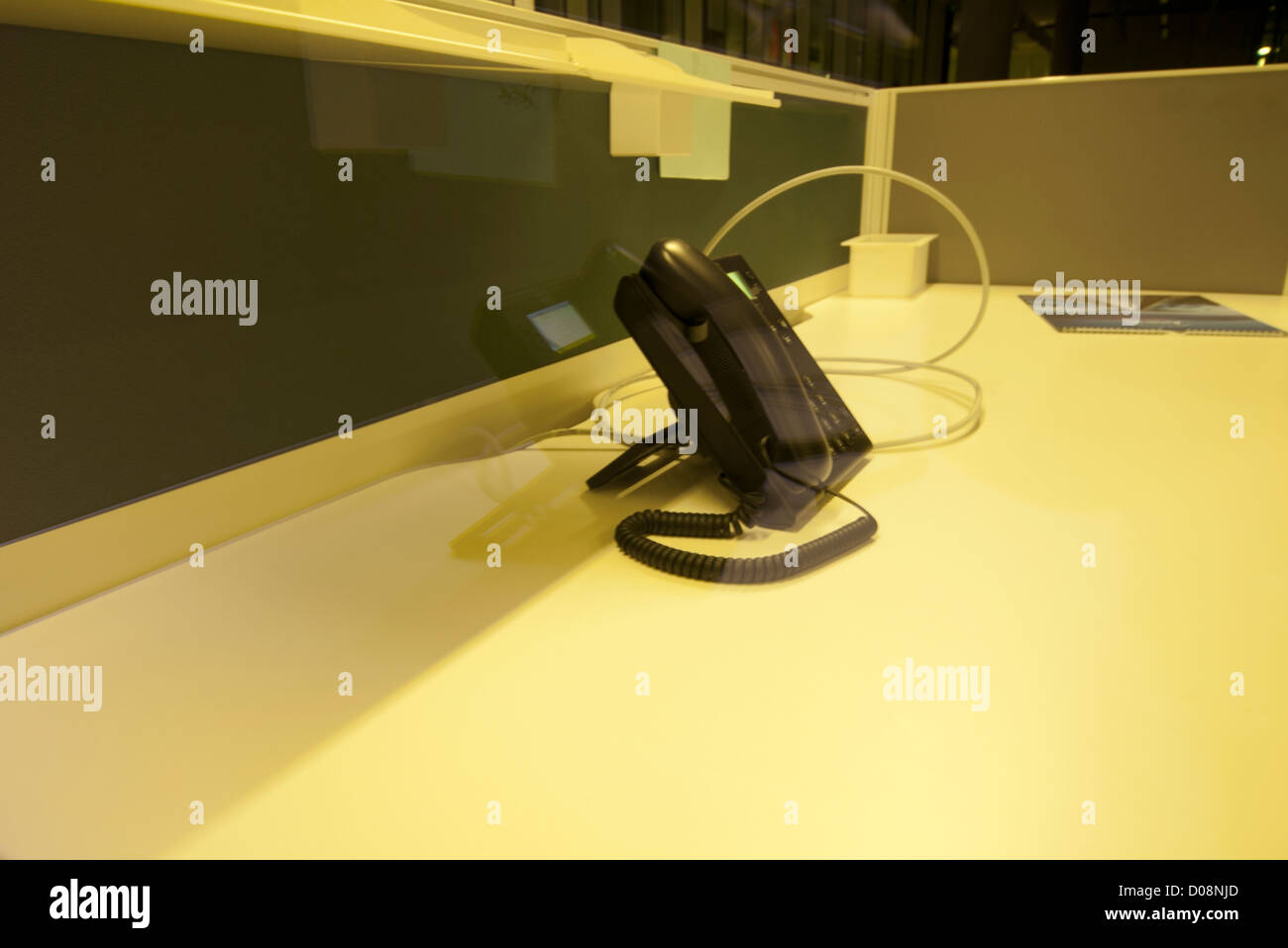 Telefon auf leerer Schreibtisch am Ende des Tages in Bürogemeinschaft Raum. Stockfoto