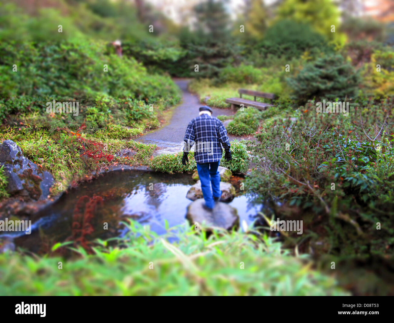 Älterer Mann Kreuzung Stream. Stockfoto