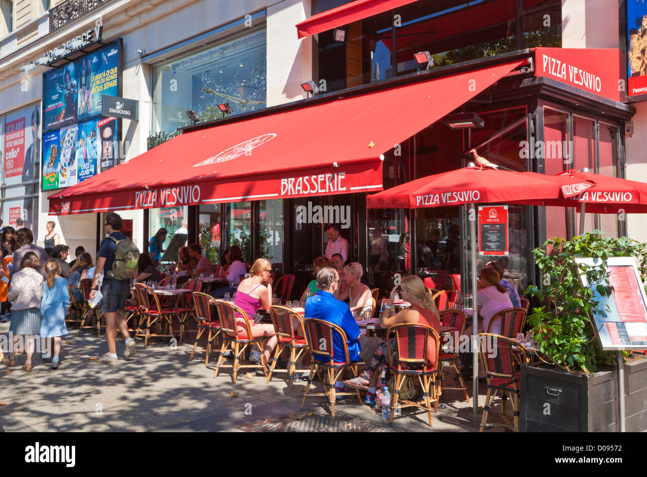 Leute sitzen in einem Café auf der berühmten Einkaufsstraße Avenue des Champs Elysees Paris Frankreich EU Europa Stockfoto