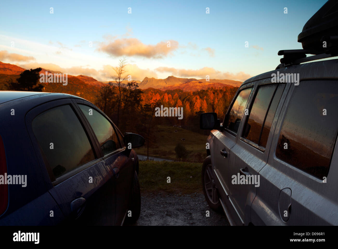 Zwei Fahrzeuge abgestellt, am frühen Morgen den Sonnenaufgang zu beobachten, über Tarn Hows und größere Langdale, englischen Lake District, Großbritannien Stockfoto