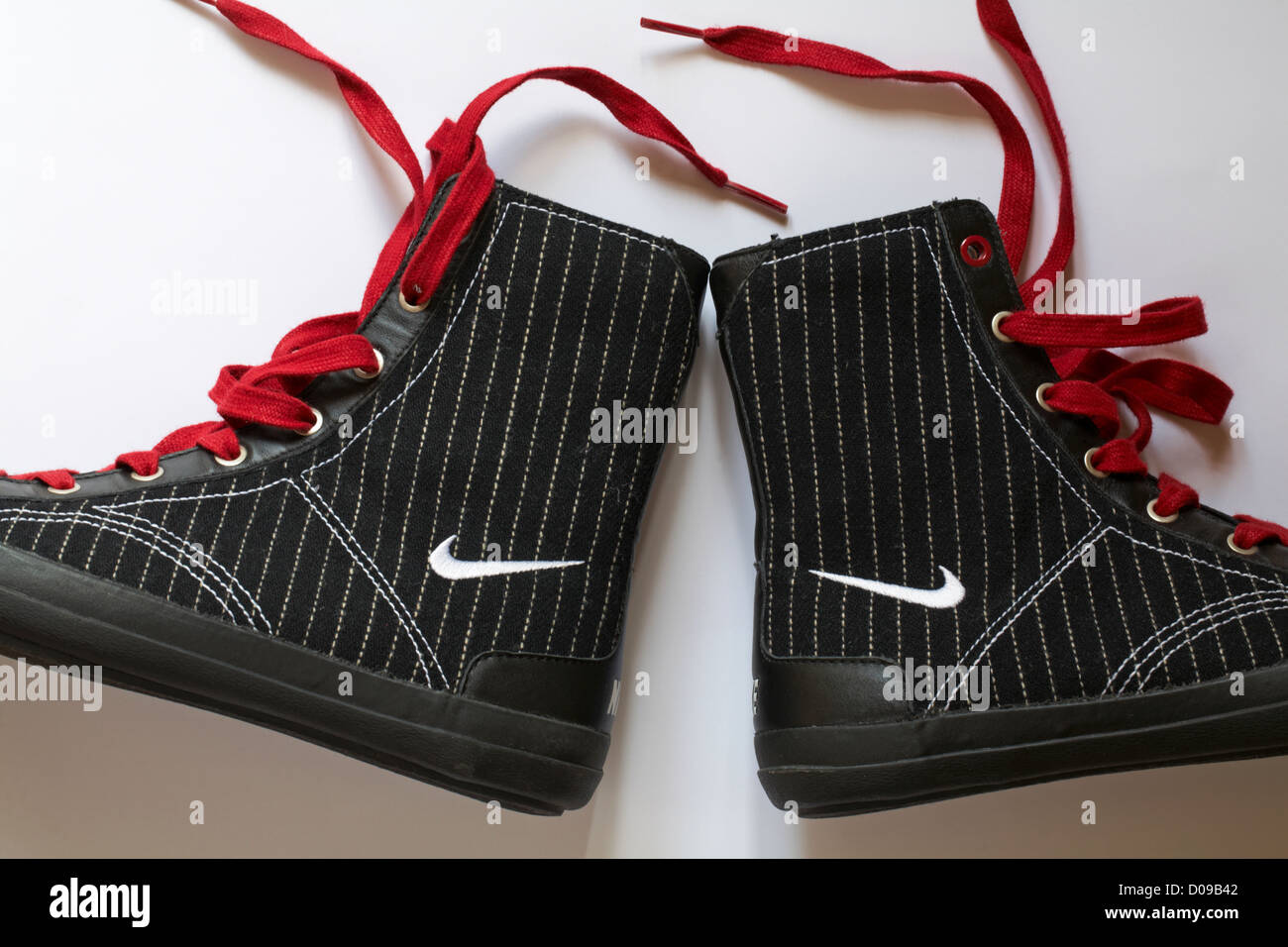 Stiefel mit Nike Logo und rote Schnürsenkel setzen auf weißem Hintergrund Stockfoto