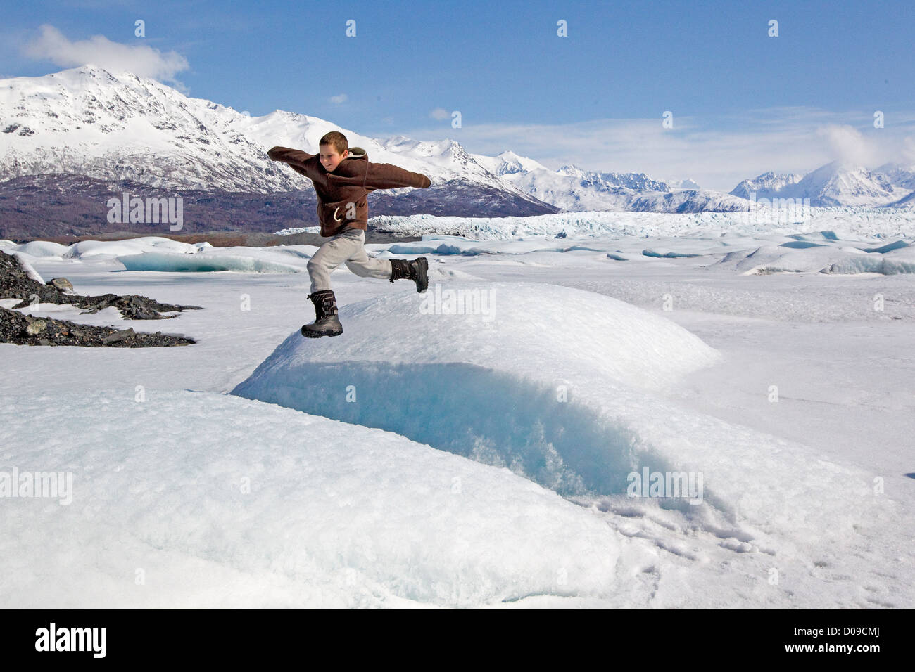 Junge springt auf Gletscher in Alaska, Alaska, Chugach Mountains, Alaska, USA Stockfoto