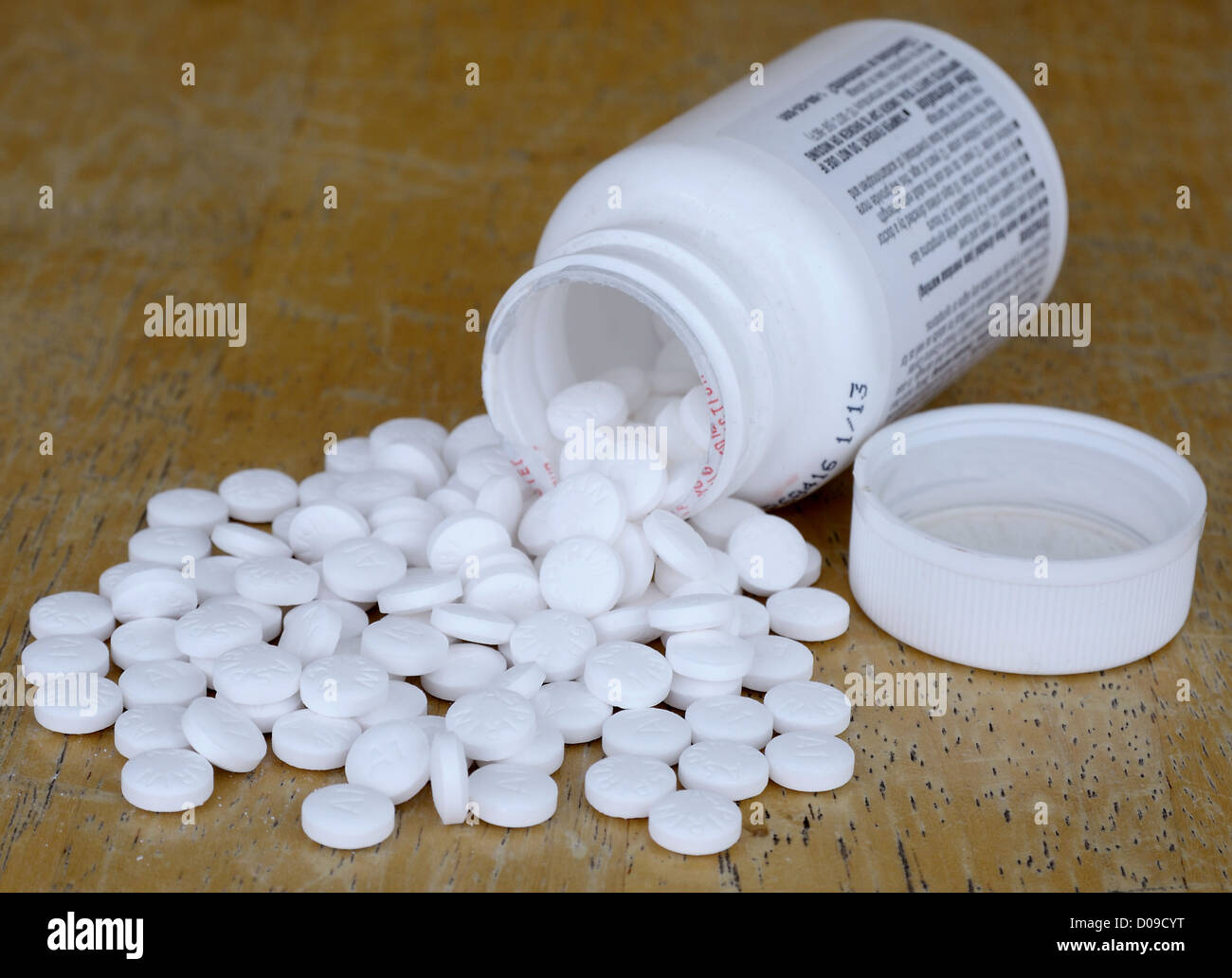 viele Aspirin verschüttet aus Aspirin-Flasche auf die Seite legen Stockfoto