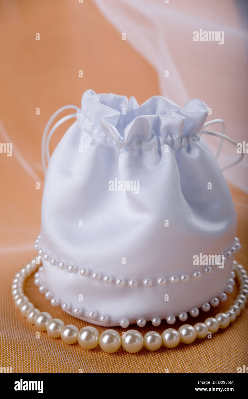 Braut weiße seidige Handtasche mit Perlen und Schleier auf Beige Hintergrund Stockfoto
