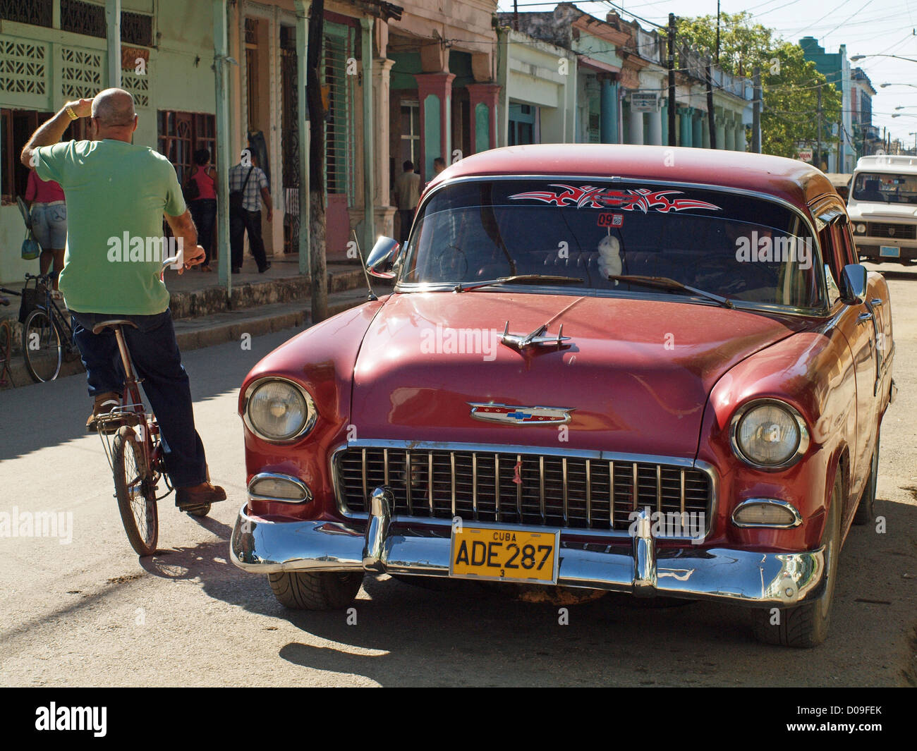 Rot der 1950er Jahre amerikanische Oldtimer in Moron Kuba in typischen kubanischen Straße mit Radfahrer ausweichen entlang fahren Stockfoto