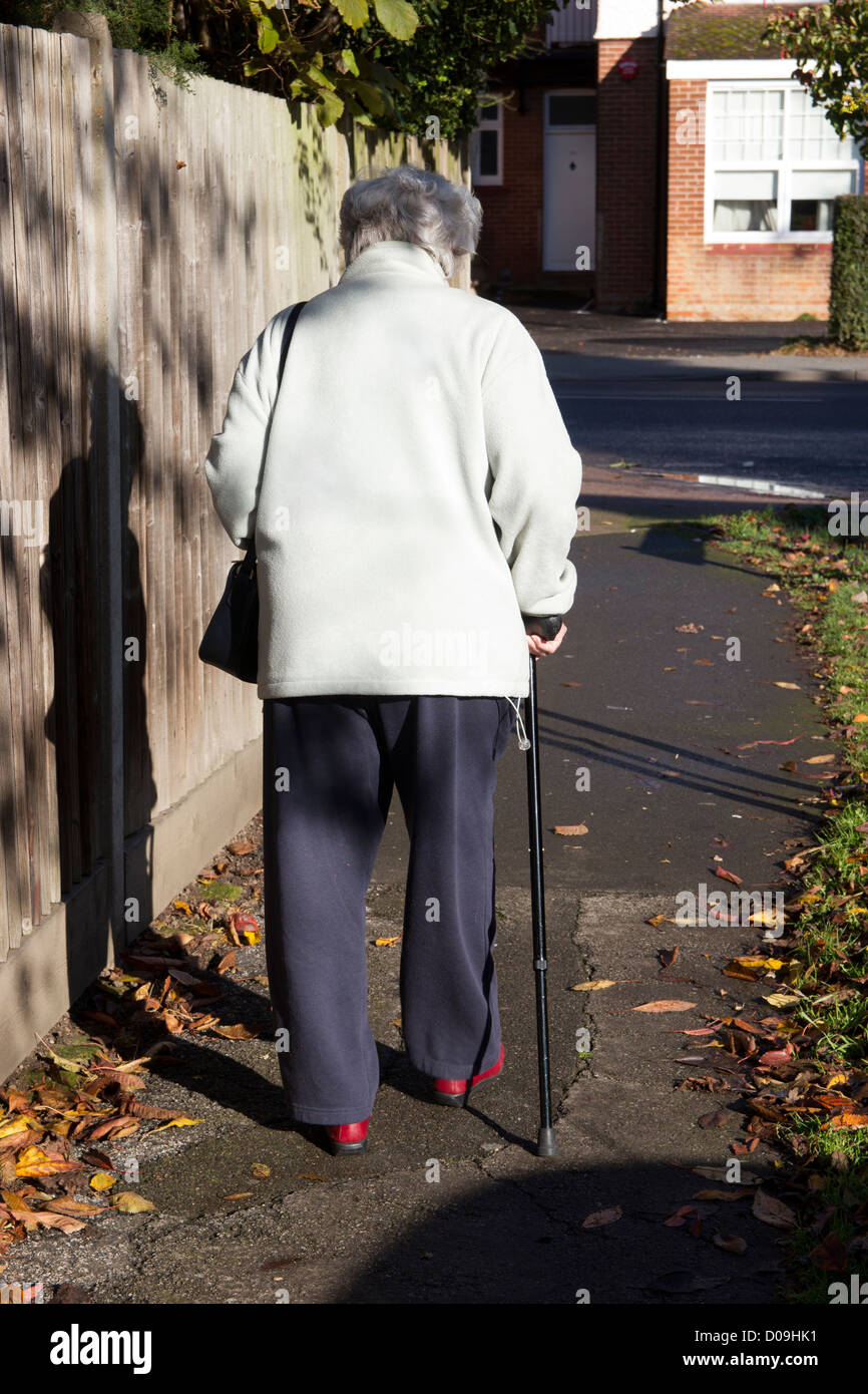 Ältere Dame allein mit Stock zu Fuß. OAP-Rentner Stockfoto