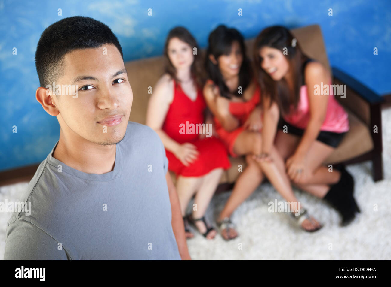 Hübscher Latino Teenager mit treuen Freundinnen auf sofa Stockfoto