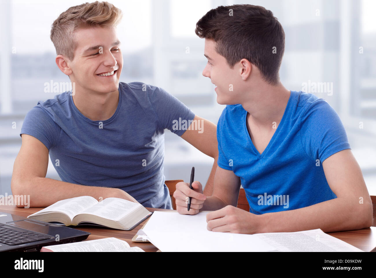 Zwei junge Burschen, die zusammenarbeiten, um die Bibel zu studieren Stockfoto