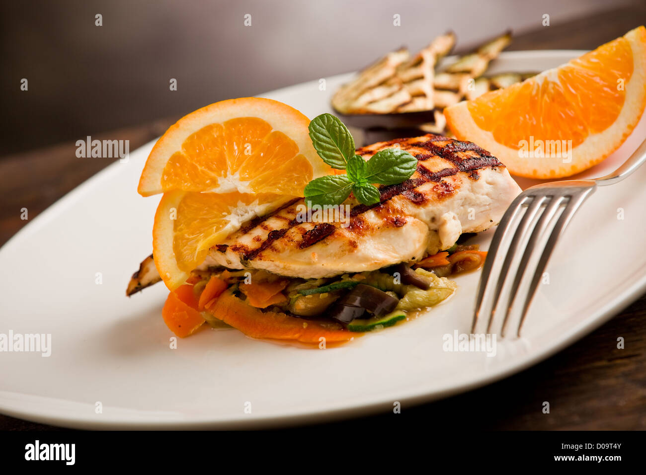 leckere gegrillte Hähnchenbrust mit Orangen auf Ratatouille Bett Stockfoto