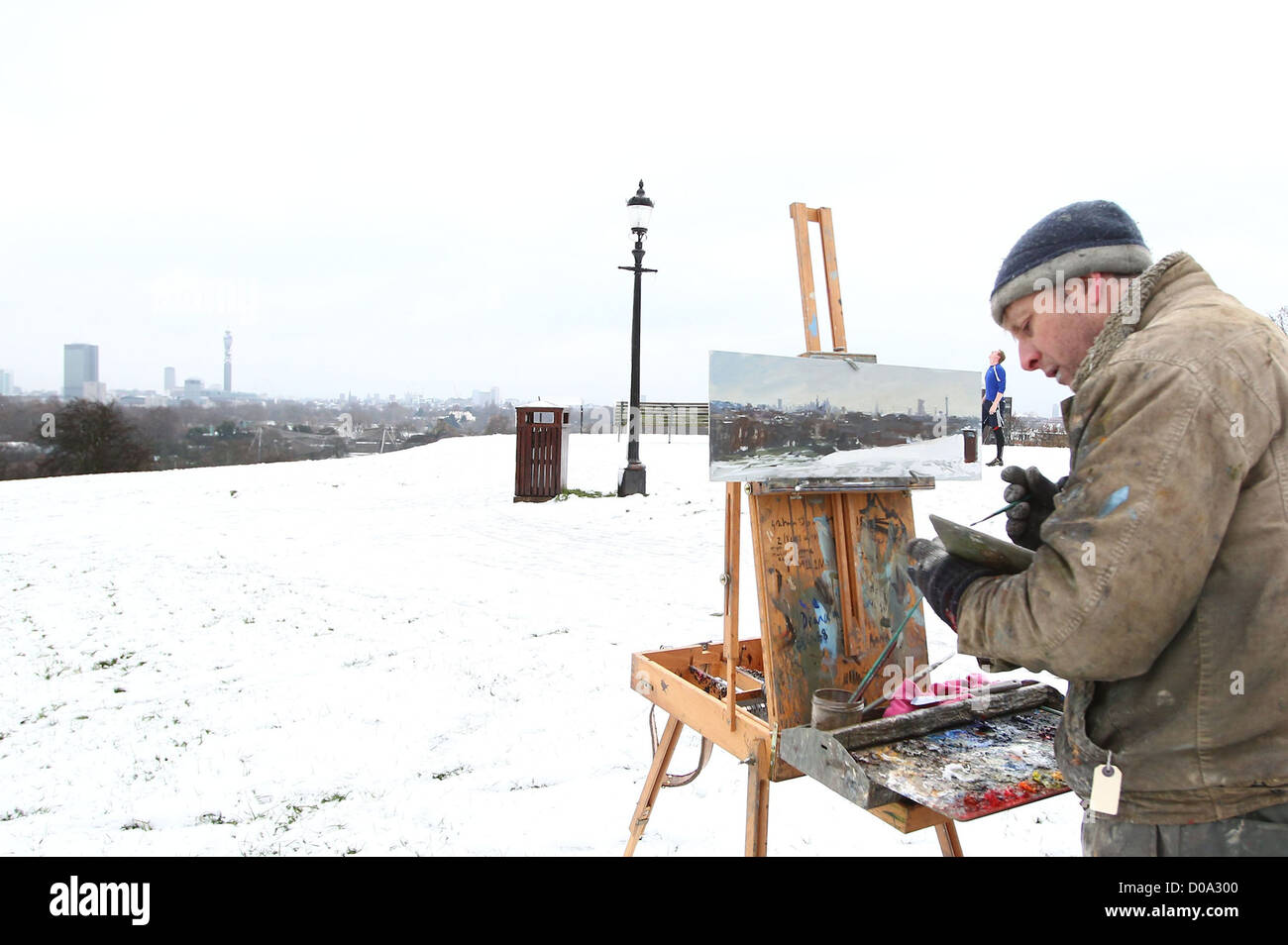 Britischer Impressionist Maler Peter Brown, bekannt als "Pete the Street" - eines lokalen Künstlers von Primrose Hill, malt eine Schnee-Szene der Stockfoto