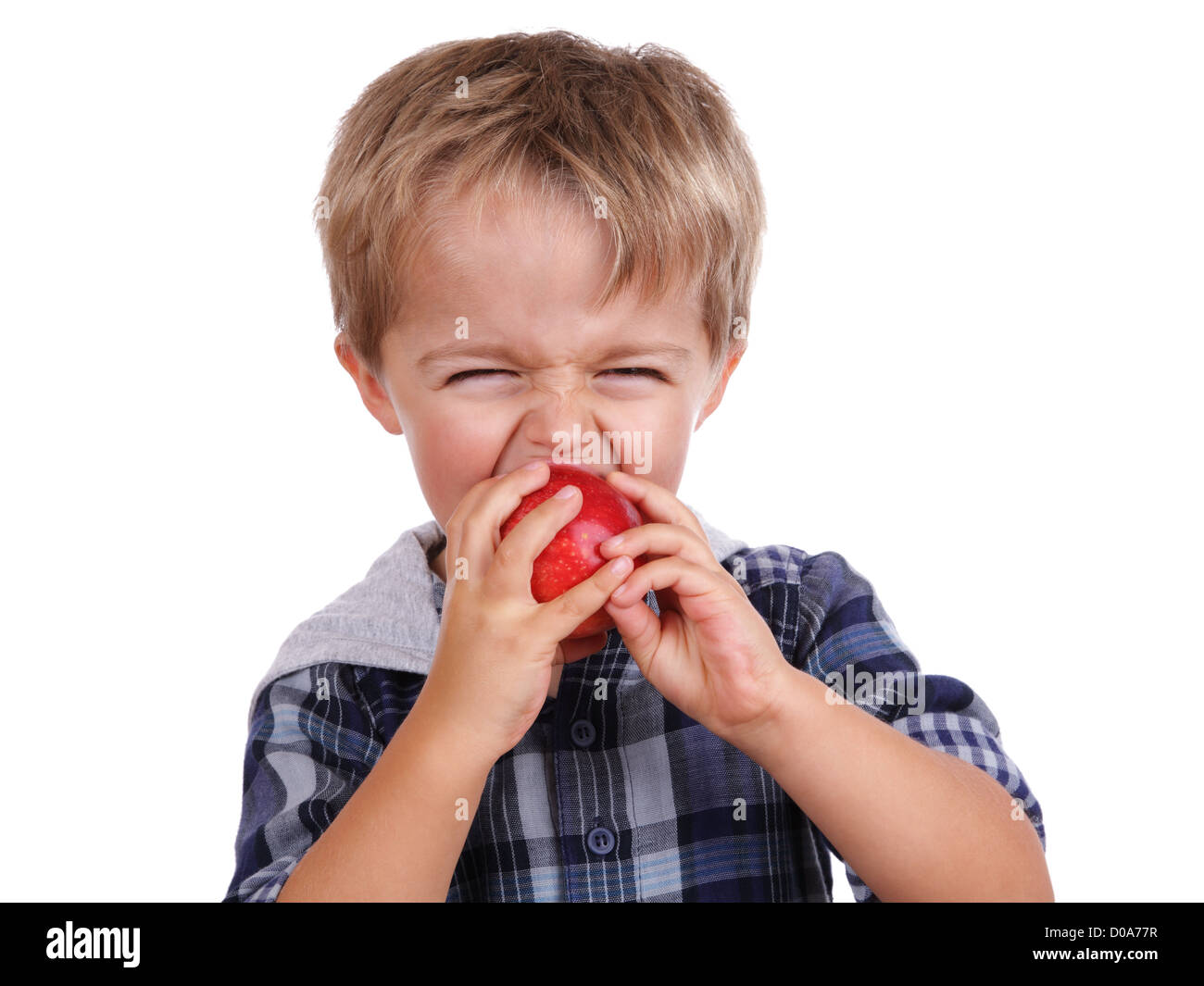 Junge, die einen roten Apfel beißen Stockfoto