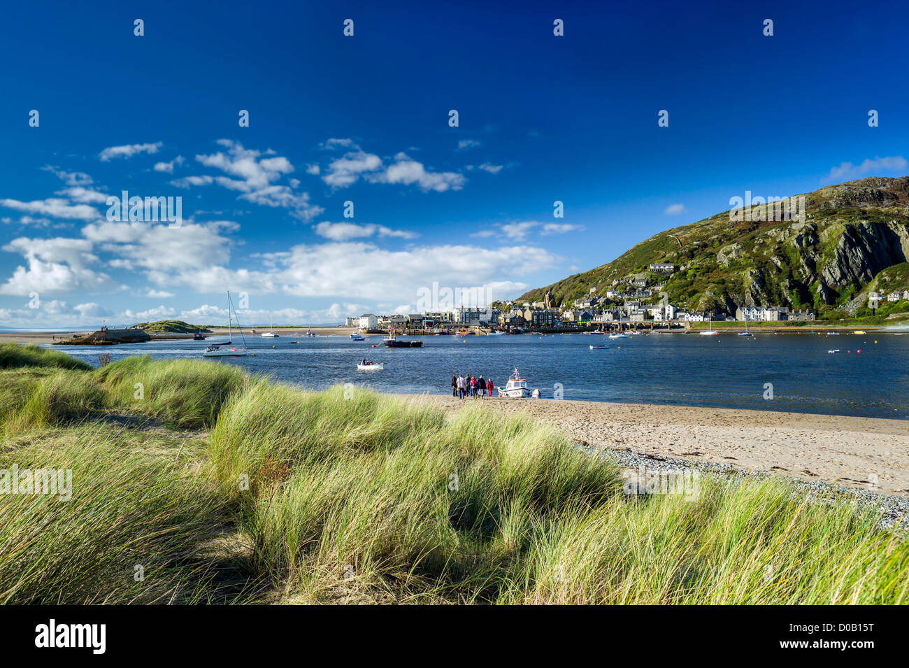 Blick über Strandhafer gegenüber einer Gruppe von Touristen warten am Strand für eine Fähre über den Mawddach Mündung zu Barmouth Stockfoto