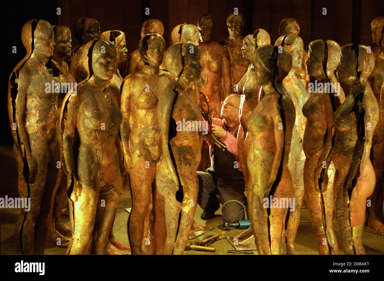 Bildhauer Peter Burke arbeitet an seiner Kupfer Figuren von Männern und Frauen Stockfoto