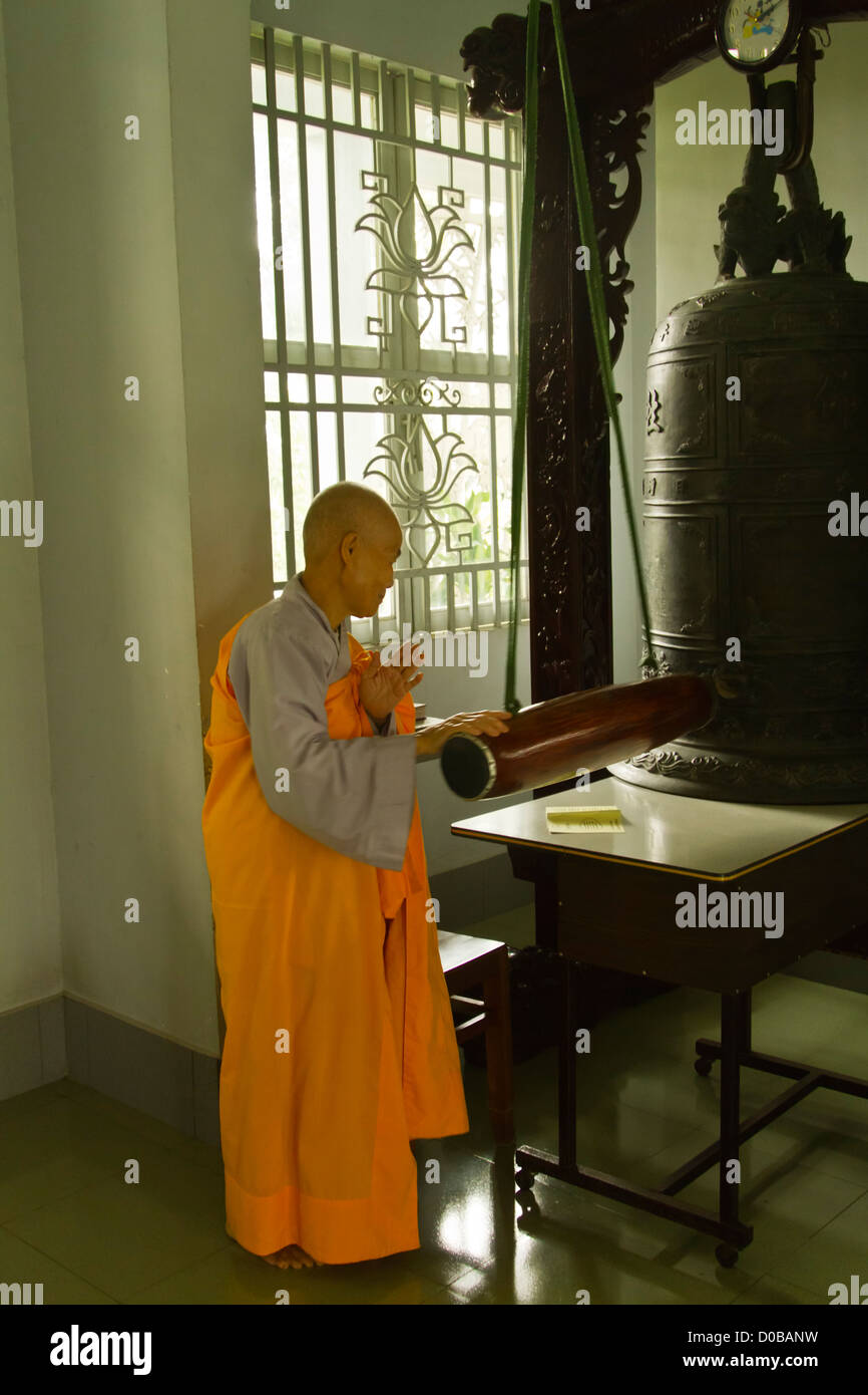 Buddhistische Nonne Ringe willkommen Glocke in einem Kloster im Mekong-Delta, Vietnam. Stockfoto