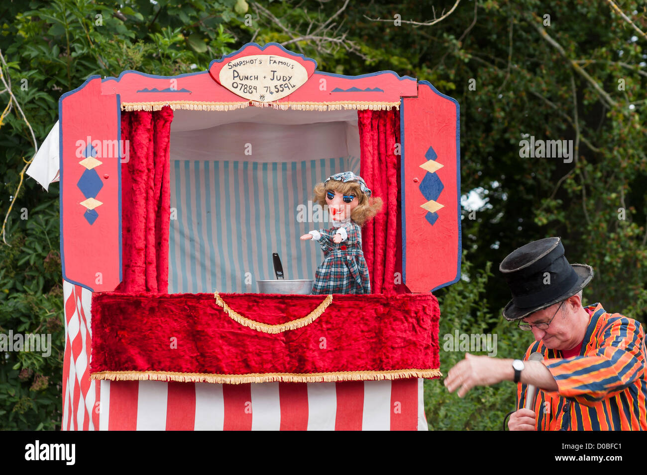 Punch and Judy Show mit Puppenspieler im Zylinder Stockfoto