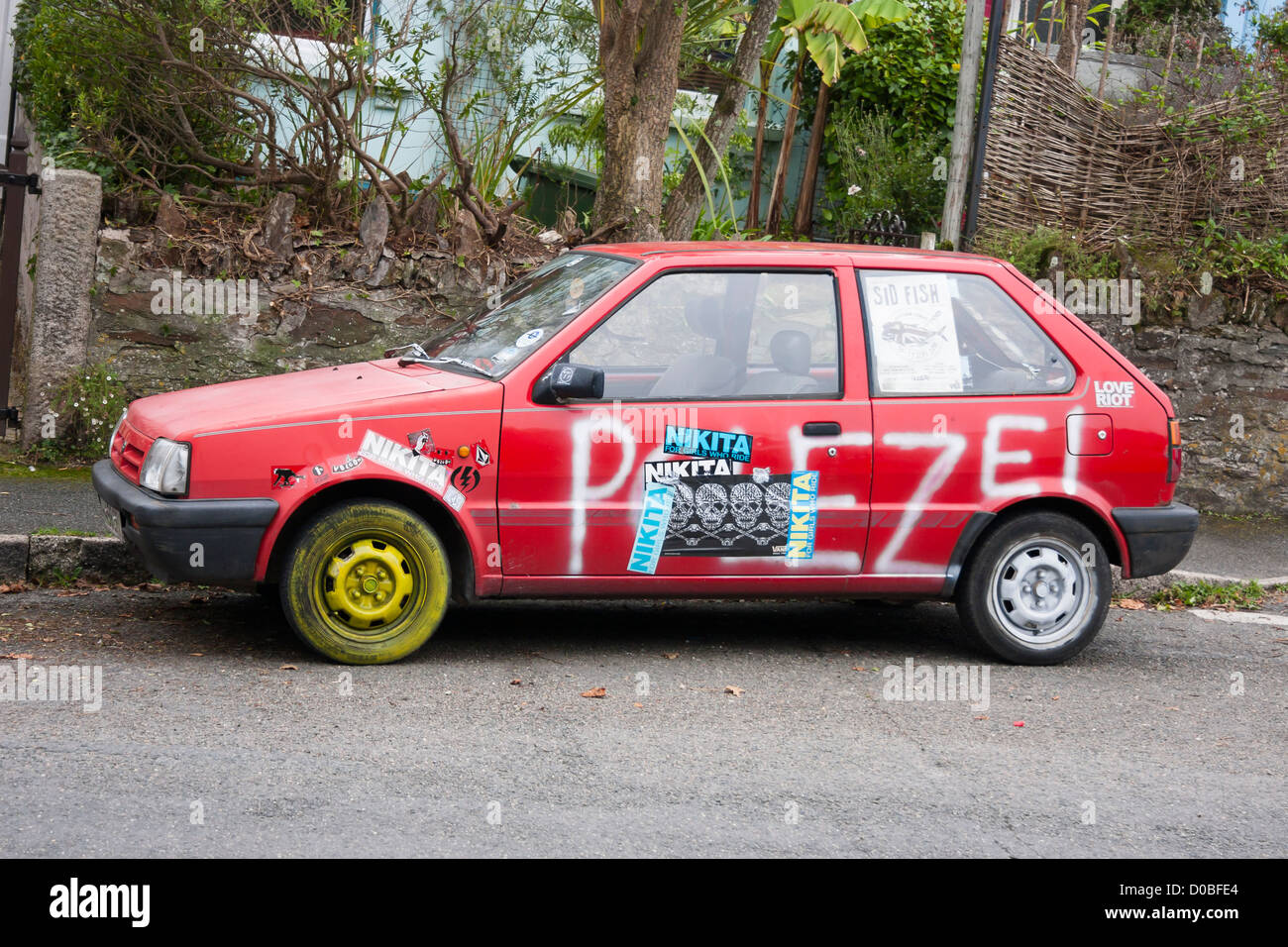 Grunge rotes Auto mit Graffiti-Farbe und Plakate Stockfoto