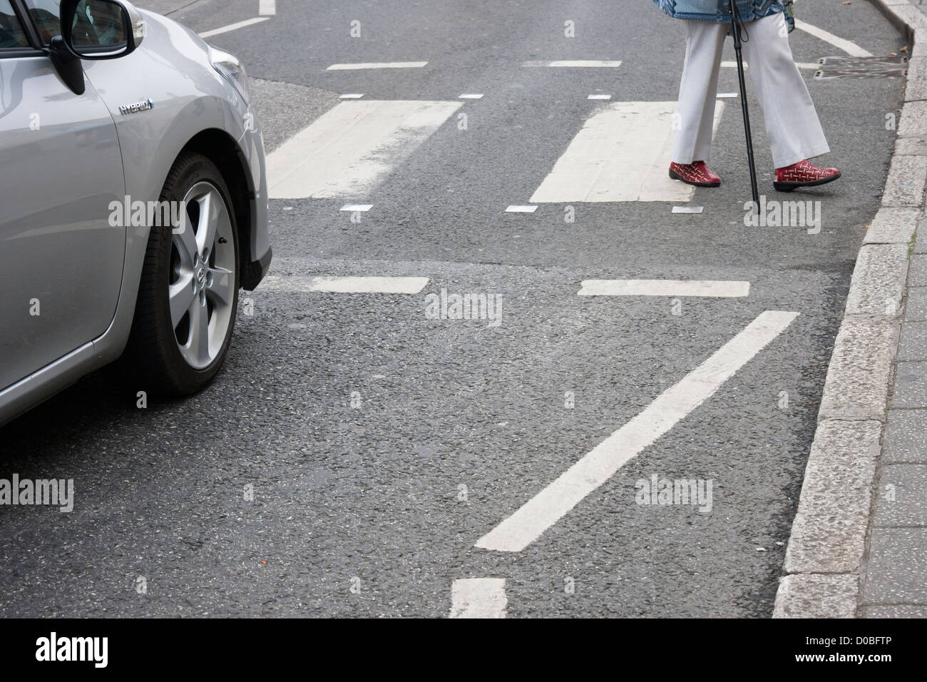 Rentner mit Gehstock auf Pelikan Überfahrt mit Auto warten Stockfoto