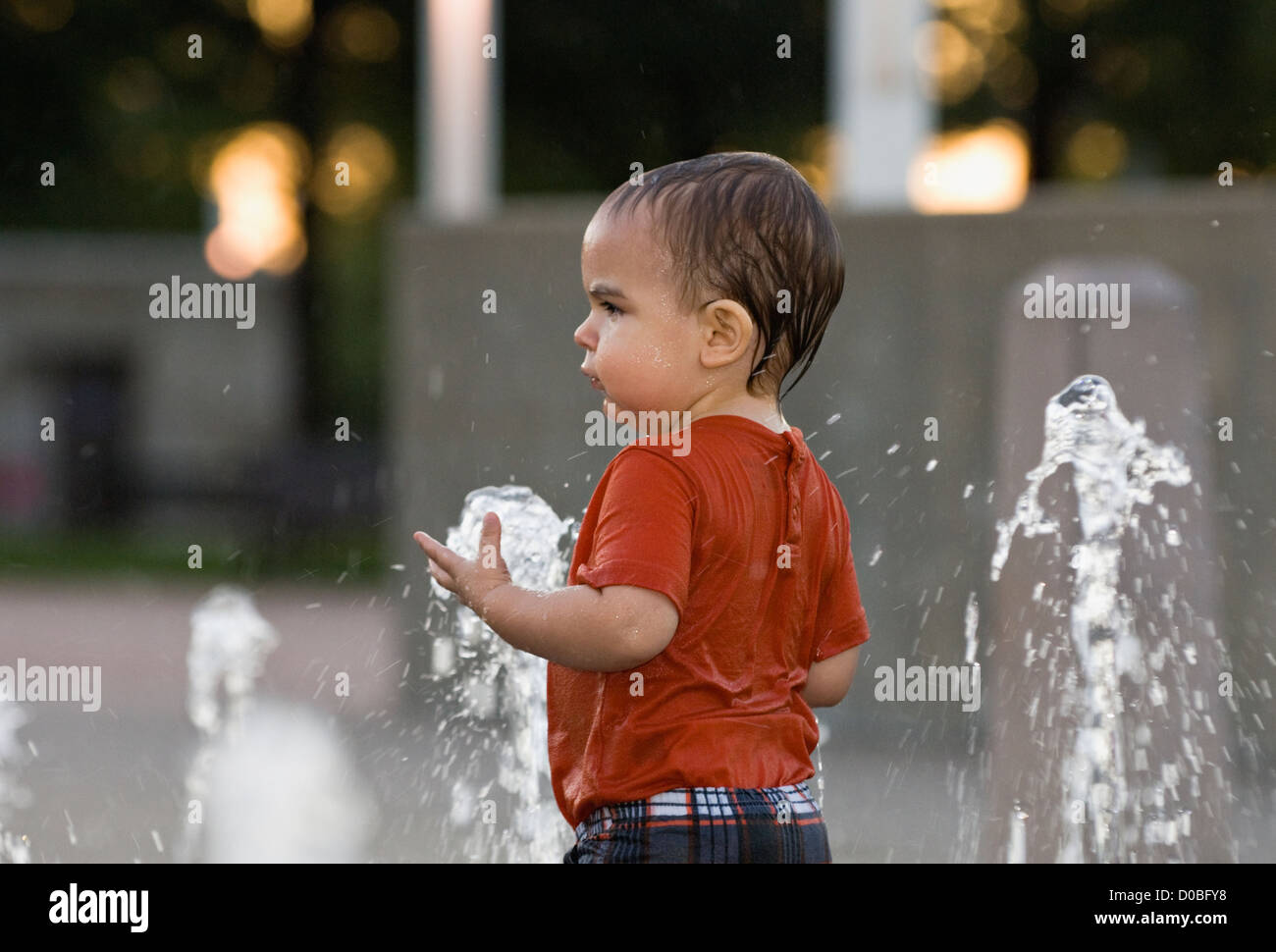 Kleinkind spielt in Brunnen im Waterfront Park in Louisville Stockfoto
