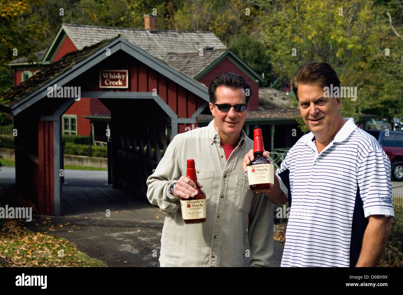 Zwei Männer halten sich Flaschen des Herstellers Mark Bourbon während Besuch Maker Mark Destillerie in Loretto, Kentucky Stockfoto