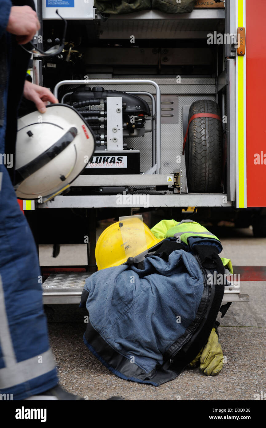 Re Feuerwehrmann weiße Uhr in Pontypridd Feuerwache in S Wales - Feuerwehr Helm-Mantel und Handschuhe auf der Fußplatte Stockfoto