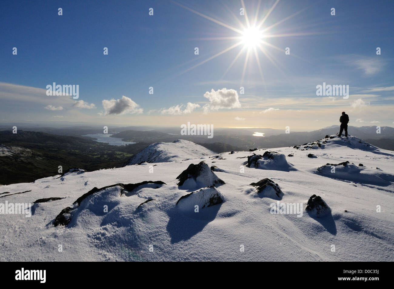 Walker auf Schnee bedeckt Heron Hecht mit Blick auf Windermere im englischen Lake District Stockfoto