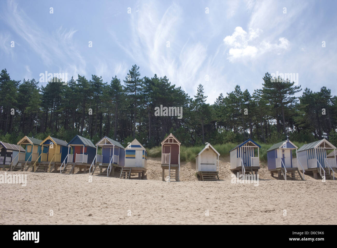 Eine Reihe von Strand Hütten am Brunnen als nächstes das Meer, Norfolk, erschossen vor einem strahlend blauen Himmel. Stockfoto