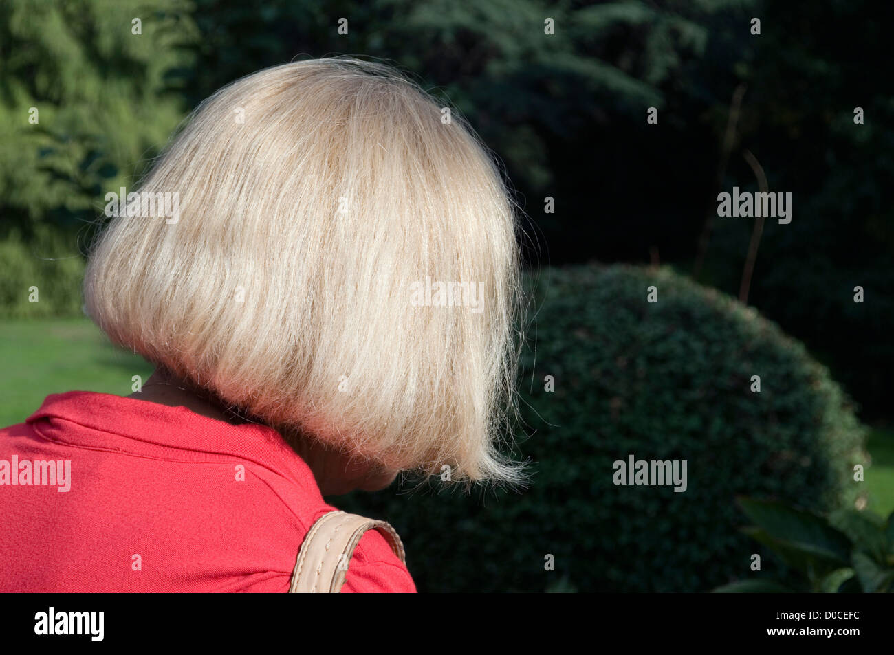 Blonde Frau im Garten Stockfoto